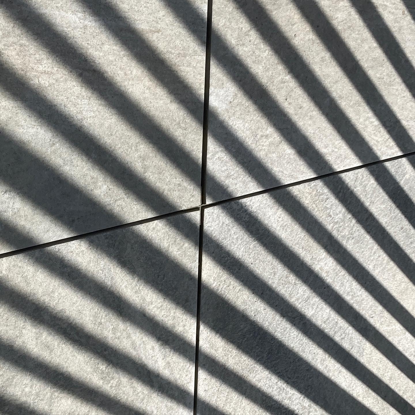 Tiles and shadow from a balcony fence